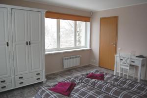 a bedroom with a bed and a desk and a window at Kaunis Guesthouse in Tallinn