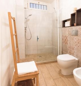 e bagno con doccia, servizi igienici e sedia. di Il salottino in via Carlo Alberto a Torino