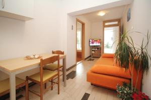 a living room with a table and an orange chair at House Vera in Baška Voda