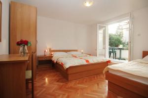 a bedroom with two beds and a window at House Vera in Baška Voda