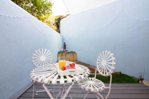 a table and chairs on a patio with a drink at Magdalen Quarters in Exeter