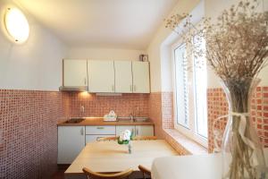 a kitchen with a table and a vase of flowers at House Vera in Baška Voda +170 photos