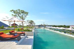 una piscina in un resort con sedie e ombrellone di Aryaduta Bali a Kuta