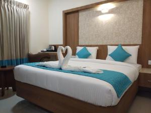 哥印拜陀的住宿－Hotel iStay，一间卧室配有一张带两个天鹅毛巾的床