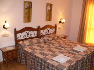 a bedroom with a bed with a checkered bedspread at Apartamentos Casanova in Nerja