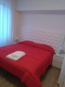 a bedroom with a red bed with a red blanket at Itaka in LʼAquila