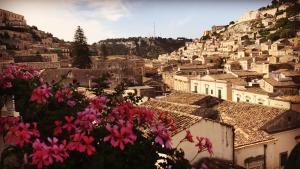 a view of a city with pink flowers at I Tetti di Siciliando in Modica