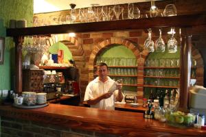 a man standing behind a bar holding a glass at Apartments Savina in Budva