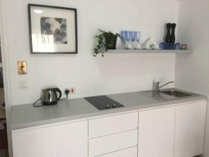 eine weiße Küche mit Arbeitsplatte und Spüle in der Unterkunft Pasithea Holiday Apartments in Larnaka + 48 Fotos