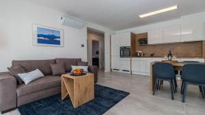 a living room with a couch and a table and a kitchen at Apartment Di Blu in Novi Vinodolski