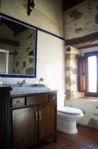 y baño con aseo, lavabo y espejo. en Casa Rural El Molino I, en San Bartolomé de Pinares