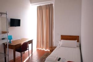 a bedroom with a bed and a table and a desk at Pigal in Tarragona