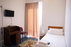 a bedroom with a bed and a desk and a television at Pigal in Tarragona