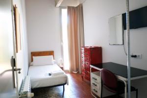a small bedroom with a bed and a desk at Pigal in Tarragona