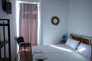 a bedroom with a bed and a chair and a mirror at Pigal in Tarragona