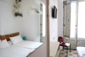 a bedroom with a bed and a window and a chair at Pigal in Tarragona