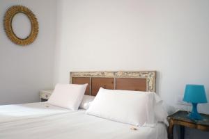 a bedroom with a bed with white sheets and a mirror at Pigal in Tarragona