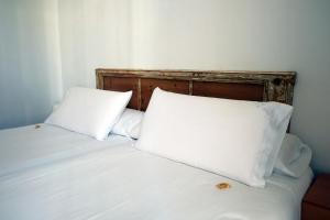 a bed with two white pillows and a wooden headboard at Pigal in Tarragona