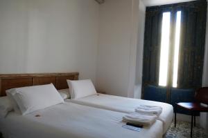 a bedroom with two beds with white sheets and a window at Pigal in Tarragona