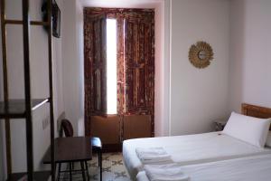 a bedroom with a bed and a window and a chair at Pigal in Tarragona