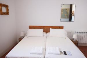 2 camas en una habitación con sábanas blancas en Pigal, en Tarragona