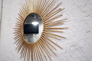 a gold sunburst mirror on a wall at Pigal in Tarragona