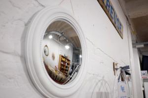 a round window in a wall with a reflection of a room at Pigal in Tarragona