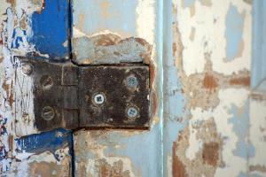 an old metal door with a rusty latch on a wall at Pigal in Tarragona