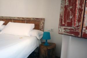 a bedroom with a bed and a blue lamp on a table at Pigal in Tarragona