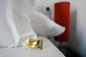 a gold object on a bed with white pillows at Pigal in Tarragona