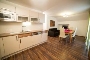 a kitchen and living room with a table and a couch at Apartments Reiterbäck in Wagrain