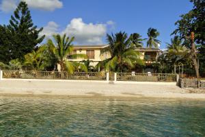 una casa en una playa con palmeras y agua en Villa Mauridul, en Baie du Tombeau
