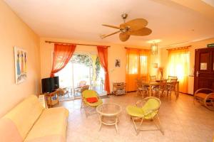 a living room with a couch and tables and chairs at Villa Mauridul in Baie du Tombeau
