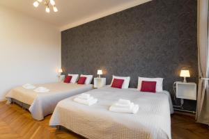 1 dormitorio con 2 camas y almohadas blancas y rojas en Vincanto Apartments, en Praga