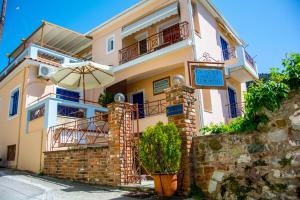 a house with an umbrella in front of it at Koukounaries Apartments Limni in Límni