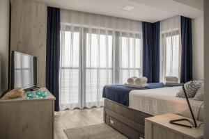a bedroom with a bed and a tv and windows at Apartment Di Blu in Novi Vinodolski +94 photos