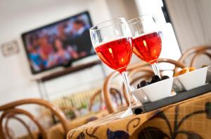 deux verres de vin rouge assis sur une table dans l'établissement Hotel Milan, à Rosolina Mare