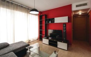 a living room with a red wall with a television at Sierra Cortina Resort in Finestrat