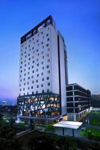 a large white building with a lit up facade at Hotel Neo+ Kebayoran Jakarta in Jakarta