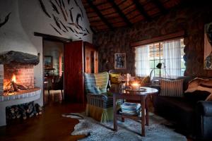 a living room with a table and a fireplace at Geiger's Camp by NEWMARK in Timbavati Game Reserve