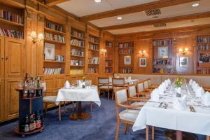 a dining room with tables and shelves of books at Leoso Hotel Ludwigshafen in Ludwigshafen am Rhein