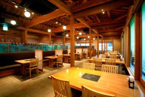 an empty restaurant with wooden tables and chairs at Kira No Sato in Ito
