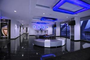 a lobby with a blue ceiling and a couch and a table at Hotel Neo+ Kebayoran Jakarta in Jakarta