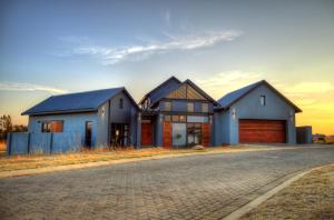 a house with three garage fronts on a street at 142 Vaal de Grace in Parys