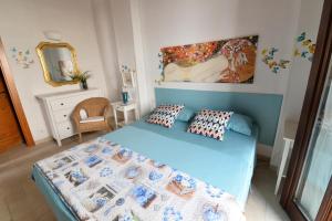 una camera con letto blu e specchio di Casa Campanelli a Monopoli