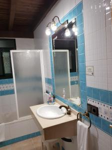 y baño con lavabo, espejo y bañera. en Casa Rural El Conde, en Antequera
