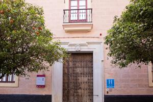- Edificio con puerta de madera y balcón en Hotel Casa de las Cuatro Torres, en Cádiz