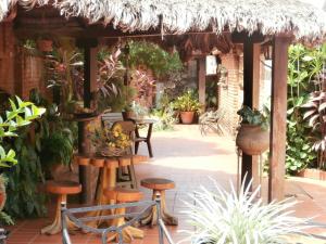 an outdoor patio with stools and a thatch roof at Apart-Hotel San Ignacio-Boutique 5 Estrellas in San Ignacio de Velasco