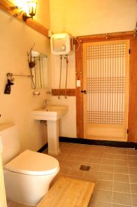 baño con aseo, lavabo y puerta en Korean Traditional House - Chungnokdang, en Boseong