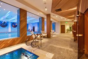 a pool in a hotel lobby with a table and chairs at Vitosha Park Hotel - Free Pool & Gym in Sofia